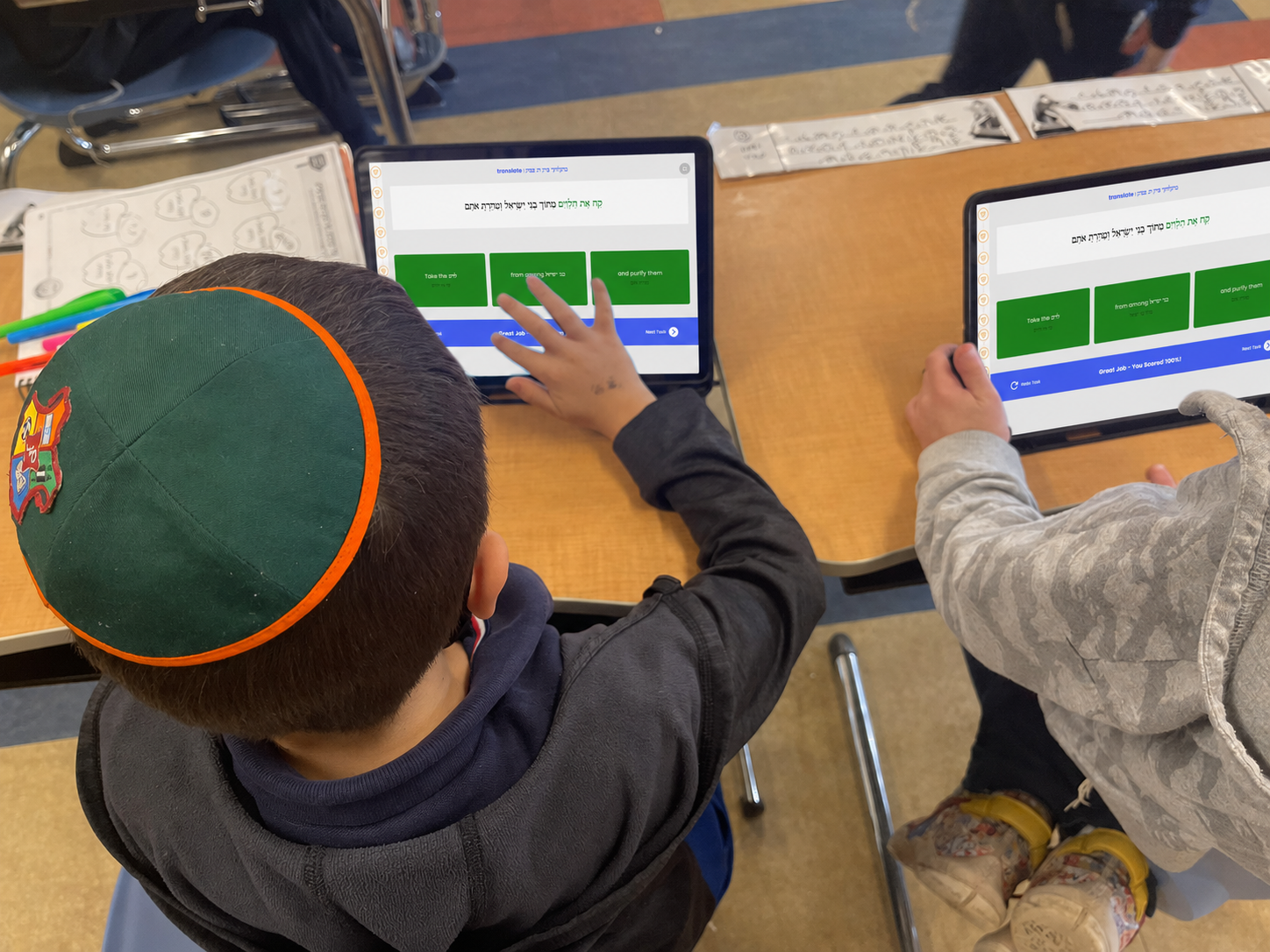 Student matching Hebrew words on a tablet
